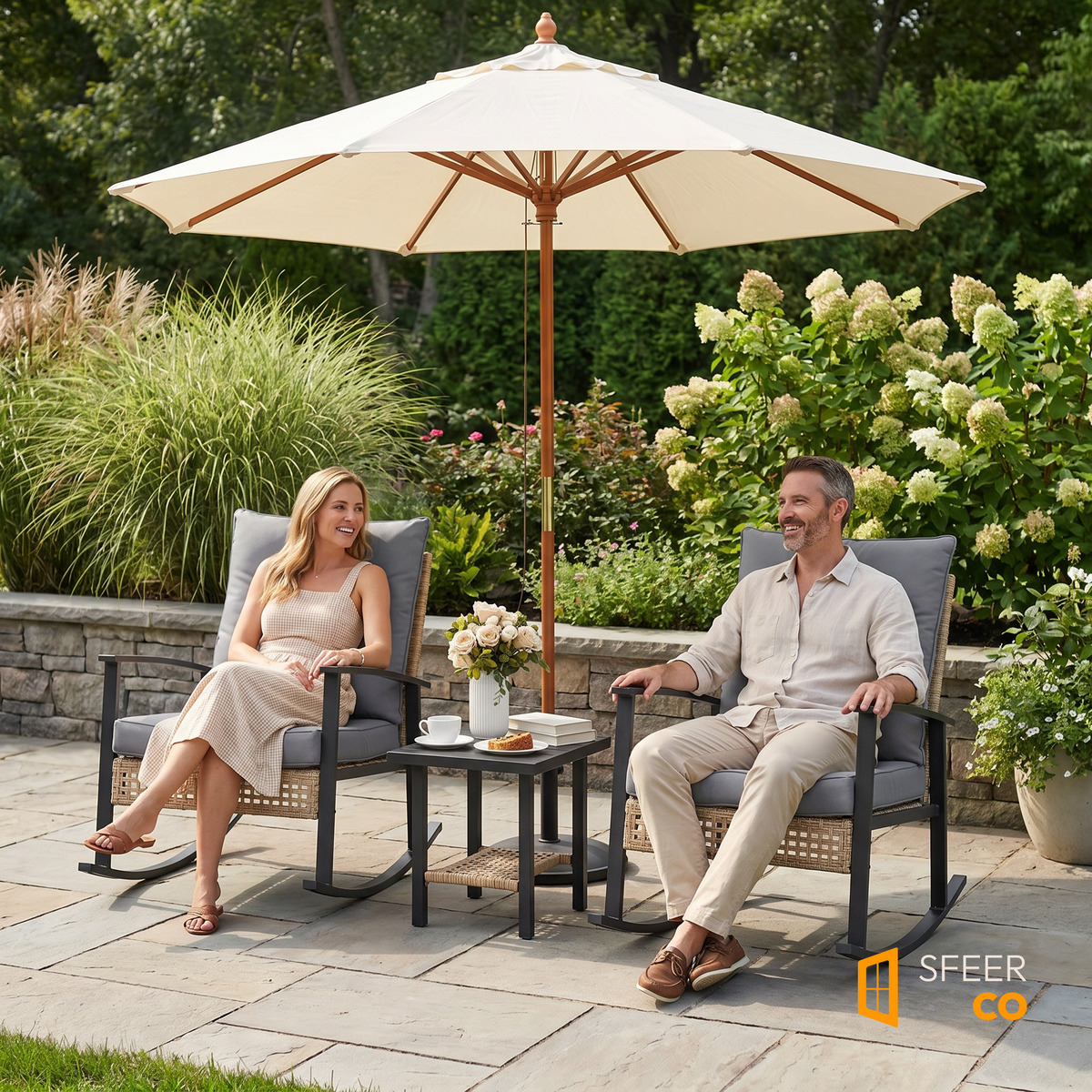 Sfeerco Deco outdoor rocking chair bistro set styled in garden patio with umbrella and couple seated