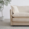 Sfeerco Dune sofa close-up detail showing beige chenille fabric texture and black wooden leg finish