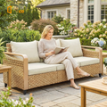 Woman relaxing on Sfeerco Lune rattan wicker outdoor sofa beige cushions garden patio