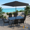 Sfeerco Riviera 8-piece patio dining set in black styled in garden setting with umbrella open